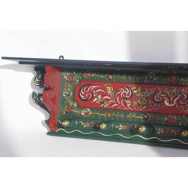 A stunning antique wall rack hand painted with floral details. The coat rack is made out of wood and is painted in...
