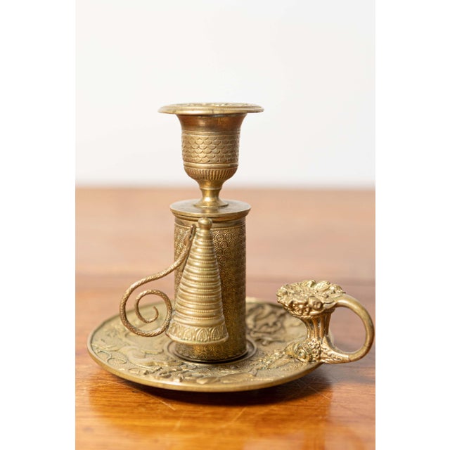 This 19th-century French candlestick is a stunning example of French craftsmanship, made of brass with intricate...
