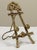 Vintage brass table easel with intricate design. Features angel figure to top with lion emblem to lower bar. Lion head...