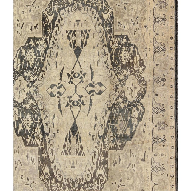 Set on a deep gray green background, this fabulous antique Turkish Sevas showcases a large and bold medallion surrounded...