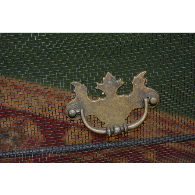 This curved screen is in good condition overall. A firm metal mesh with iron supports. Brassy pull 'handles'.