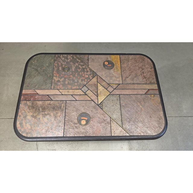 Brutalist slate and natural stone top coffee table with inlaid copper and brass. Black wooden base. The table is signed...
