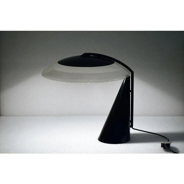 Table lamp of 1970s Italian production. Base of conical shape in painted metal, diffuser in Murano glass with canes,...