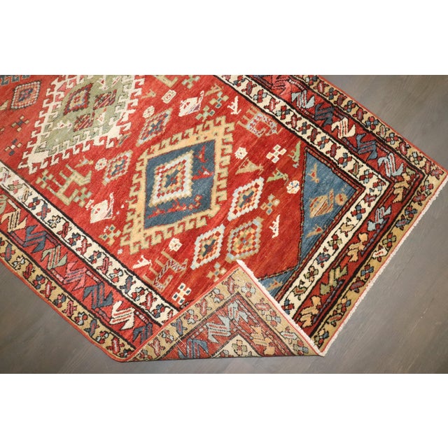 Full pile geometric antique northwest Persian runner with a red field bodied by colorful medallions, multiple borders and...