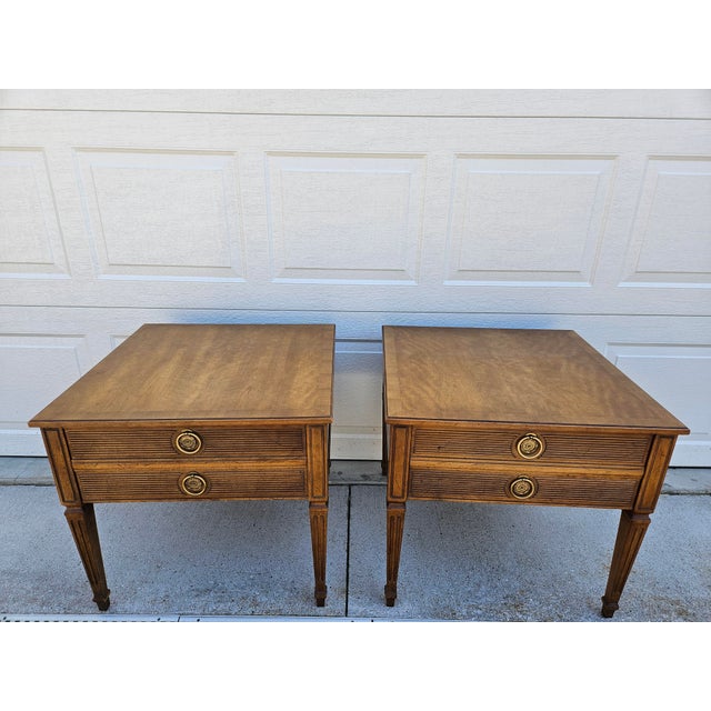 A pair of square walnut side tables by Henredon. The tables feature one drawer with beautiful brass pulls and banded tops....