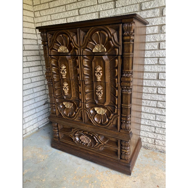 This piece is a 1970s Spanish Revival style bedroom chest, often referred to as a "Tallboy" or part of a Mediterranean-...