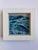 This artwork captures the dynamic movement of waves, rendered in rich shades of blue and green, suggesting both depth and...