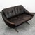 Compact 2 seater sofa in brown leather. This sofa includes tufted cushions, metal legs, and a curved arms. The leather is...