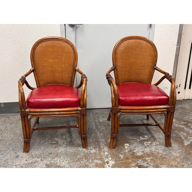 Design Plus Gallery presents a Pair of Rattan Armchairs from Palecek. The chairs have arched cane backs, tubular rattan...