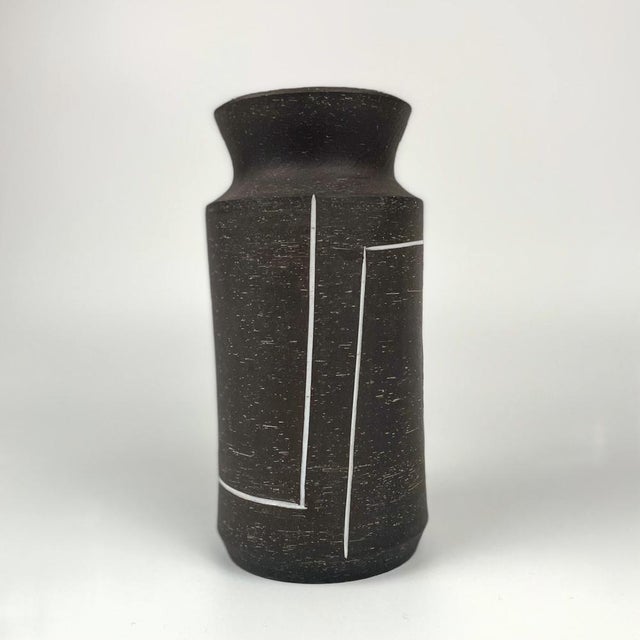 Ceramic vase with a hyperboloid body and neck by the Dutch artist Jaap Ravelli. Textured matte brown exterior with white...