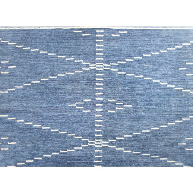 A wonderful late 20th century Indian hand-woven kilim rug with an indigo ground covered in white diagonal stripes in the...