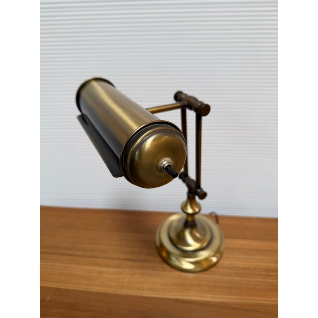 Design Plus Gallery presents a Brass Bankers Lamp from the Art Deco/Mid-Century Era. The brass metal lamp has a top...