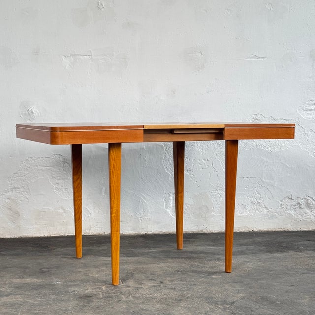 This extendable dining table is a classic piece of czechoslovak mid-century design, manufactured by jitona during the...