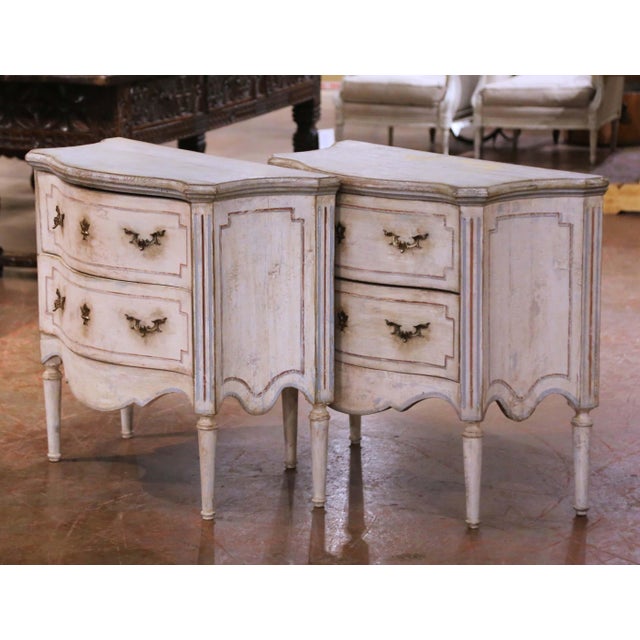 This elegant pair of antique French painted nightstands, dating to circa 1920, reflects the refined neoclassical...