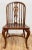 Timeless set of eight (8) vintage Windsor style dining chairs made of hard wood. Feature turned legs with stretchers, bow-...
