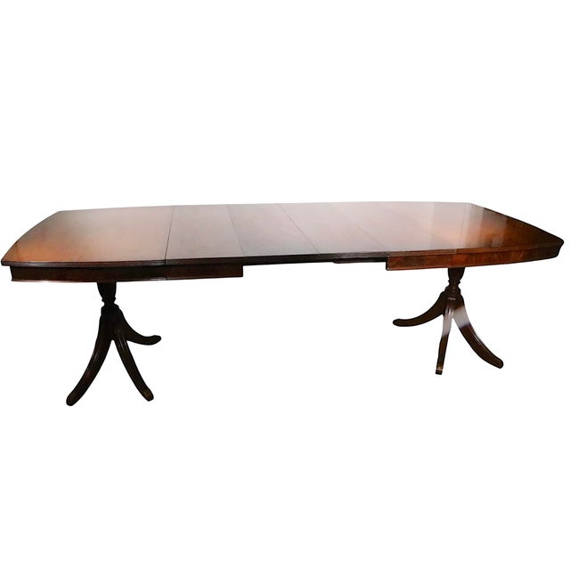 Classic Duncan Phyfe style dining table having a double pedestal base and four leaves. The table top becomes wider in the...