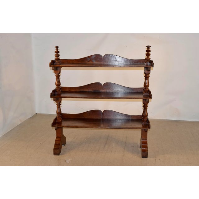 19th century British Colonial shelf made from teak. There are tall hand turned finials on the top over three shelves, all...