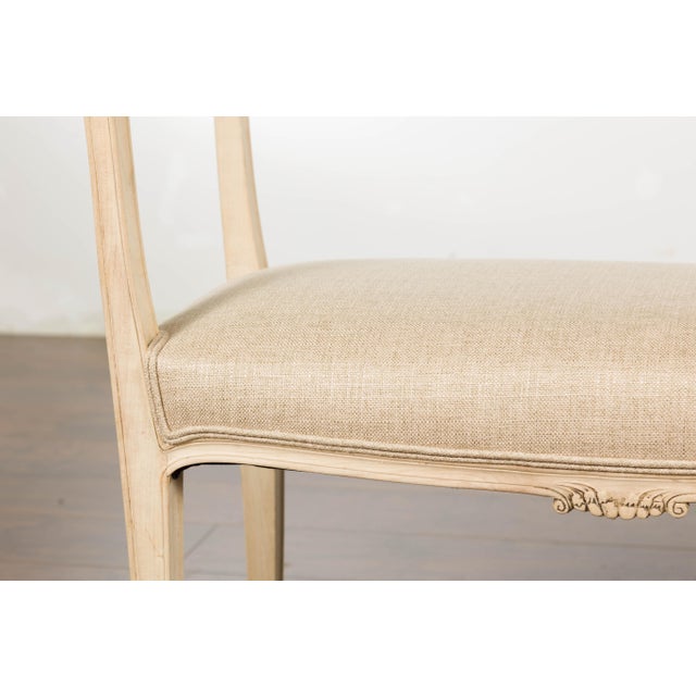 A small French walnut bench from circa 1920 with delicately carved motifs and upholstered seat. Embrace the charm of 1920s...