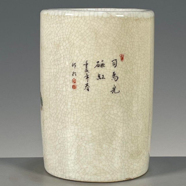 A charming Chinese porcelain brush pot (bitong). The cylindrical vessel features a creamy, all-over crackle glaze and is...