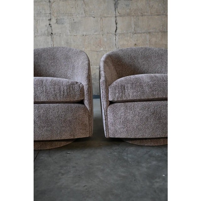 FUN pair of swivel chairs in Kravet's Cheetah Spot chenille. Minimalist shape with clean lines and arched backs. The...