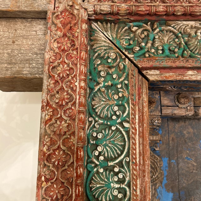 Antique hand carved Indian teak door with weathered blue paint finish and a matching hand-painted crown and frame. The...