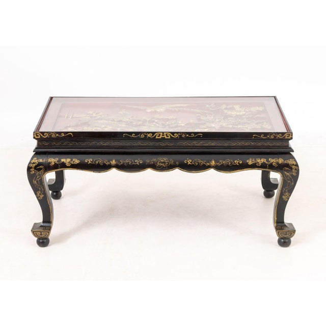 Chinoiserie Gilt and Black Lacquered Wood Low Table, the top red lacquered carved wood with birds on flowering branches...