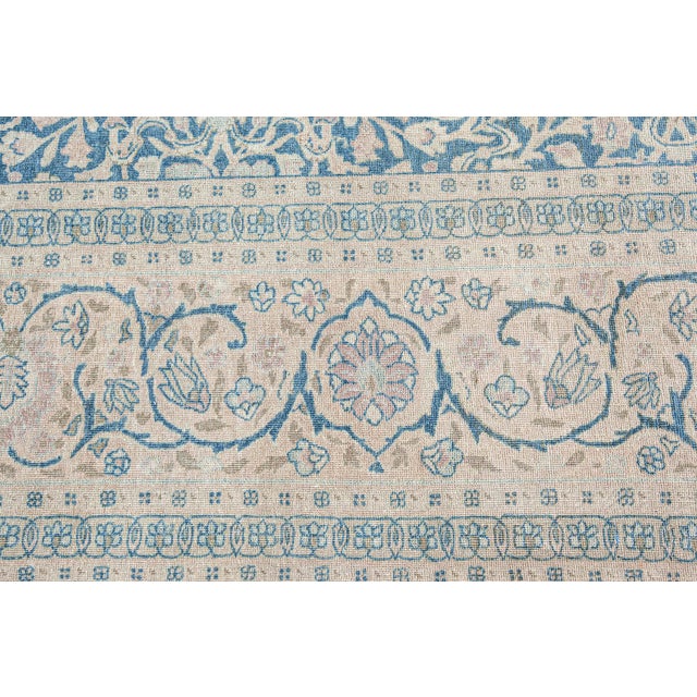 This circa 1920 antique Tabriz Persian rug features a rich blue field covered in an allover lattice of dense botanical and...