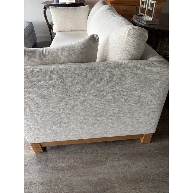 Sophisticated, yet casual....this sleek and contemporary sofa is in perfect condition. The legs and trim are of light...