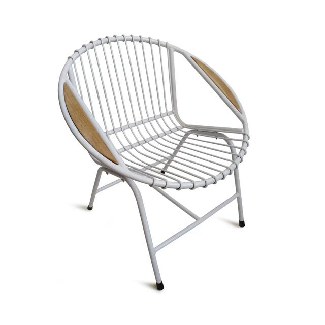 Retro ring style white finish iron outdoor chair. Fun midcentury modern round shape with teak wood insert detail on arms....