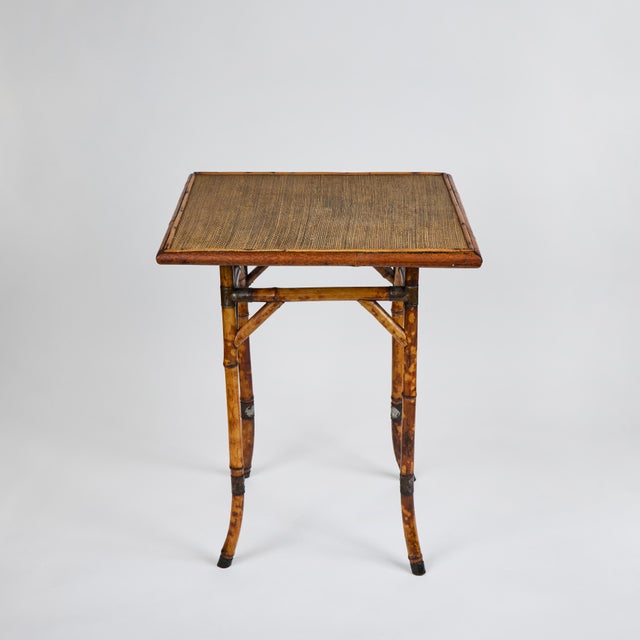 This elegant antique Chinoiserie side table was beautifully crafted with a warm tortoiseshell-finished bamboo that...