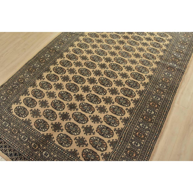 A tribal Bokhara rug hand-knotted with fine wool on a cotton foundation. This rug features rows of repeating medallions...