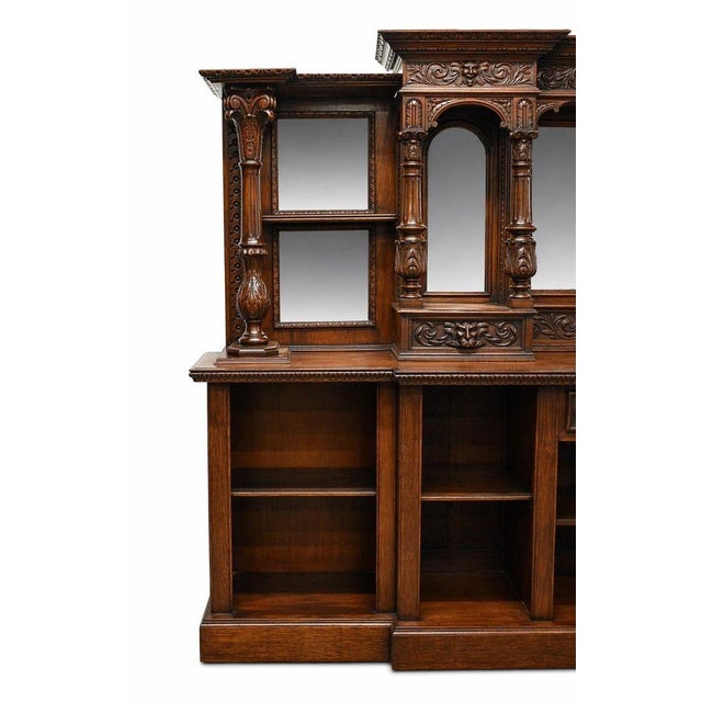 A substantial Victorian style carved oak front and back bar, richly detailed throughout and designed to create an...