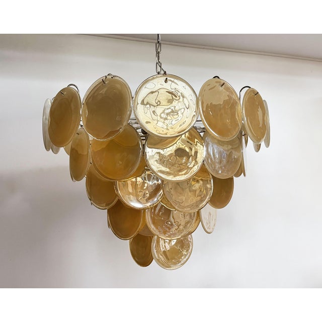 Italian murano chandelier. The chandelier has 57 murano ridescent alabaster honey discs in a nickel metal frame\. The...