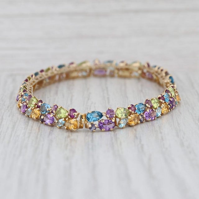 Gemstone Information: - Natural Tanzanites, Blue Topaz, Amethysts, Peridots, Citrines, Grape Garnet - Total Carats -...