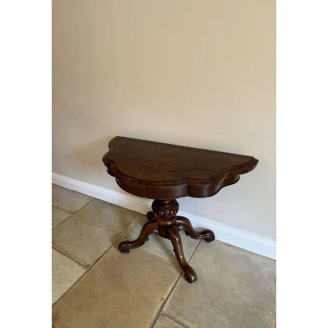 Antique Victorian quality rosewood tea table, having a quality rosewood serpentine shaped fold over top with a moulded...