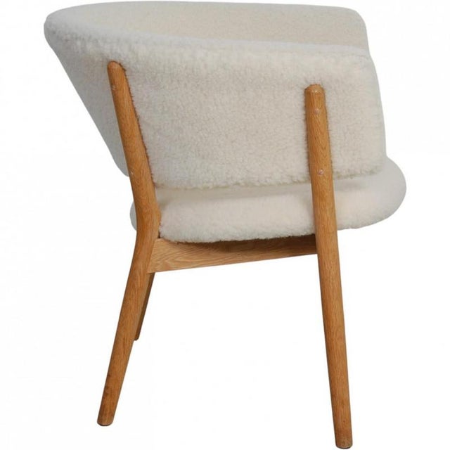 Nanna Ditzel Model 83 lounge chair with a frame of oak and reupholstered in sheep skin. The chair is from the 2000s and...