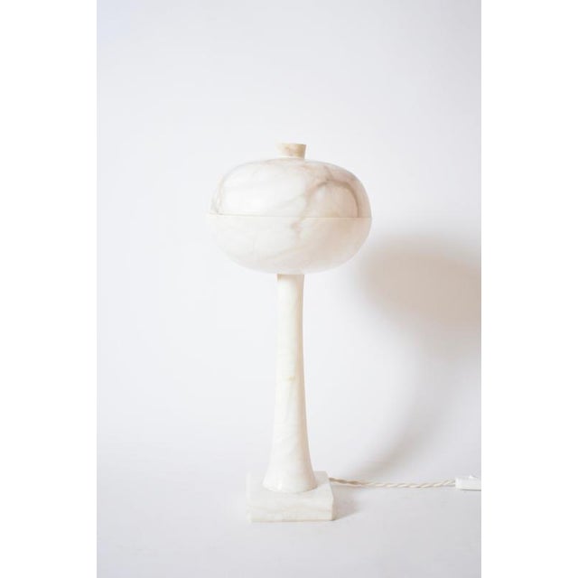 Alabaster space age mushroom lamp resting on a squqre base supporting a conic body and ending with a flattened ball....