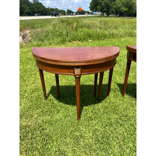An elegant pair of 19th-century French Louis XVI demi-lune side tables, crafted in richly figured mahogany with beautiful...