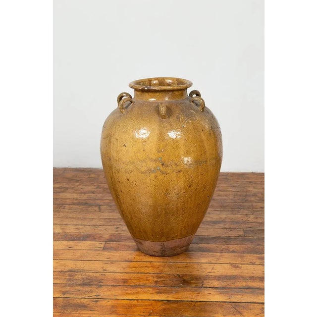 A South Eastern 19th century Martaban water jar with dragon motifs and petite handles. Used as a storage vessel to ship...