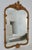 Vintage: C. 1960's; Gold gilded French Rococo-style, meets Hollywood Regency era wall mirror. It has a, prominent, foliate...