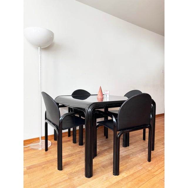 The listing includes an exceptionally rare complete dining set consisting of a black square table and four matching black...