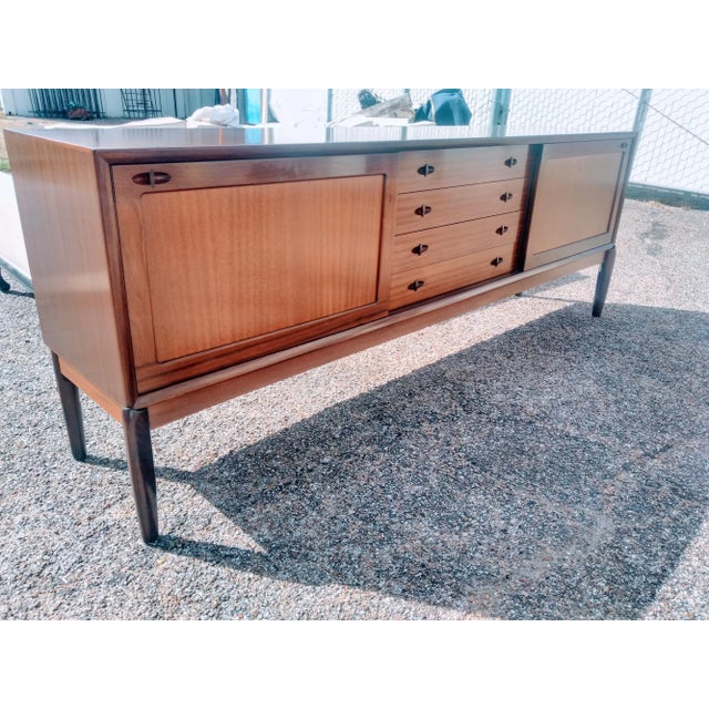 This is a 89" vintage mid century ribbon mahogany sideboard by Bramin Mobler. The sideboard has sliding doors that have...