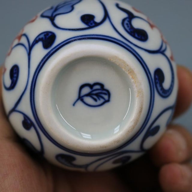 W-6cm,H-7.2cm This blue and white underglaze red porcelain vase features intricate hand-painted lotus flowers, typical of...