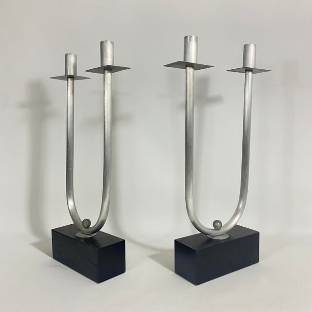 Vintage circa 1970s pair of steel tube candelabra candle holders mounted on a block of ebonized wood. Each candelabra...