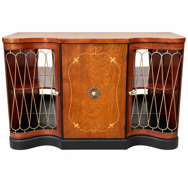 A striking vintage Art Deco style bar cabinet combining elegant curves, richly figured wood, decorative brass-tone...