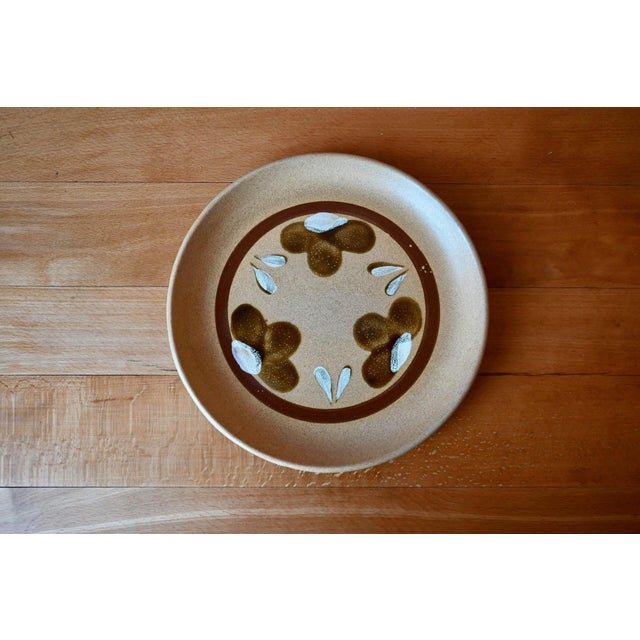 These nine stoneware dinner plates, signed Sarreguemines, evoke the 1970s taste for warm and authentic tableware. The...