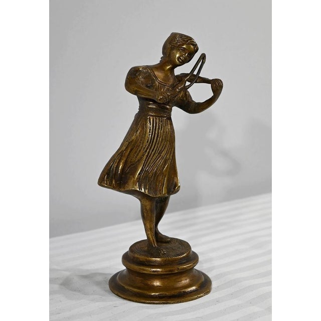 Bronze subject, with golden patina, representing a violinist in full recital. The young woman is dressed in a long dress,...