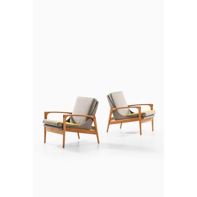 This rare pair of easy chairs, attributed to ib kofod-larsen and produced by trensums möbelfabrik in sweden, reflects the...