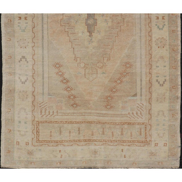 Vintage oushak Turkish rug from Anatolian region of Turkey displays muted colors and delicate tones with florals and...