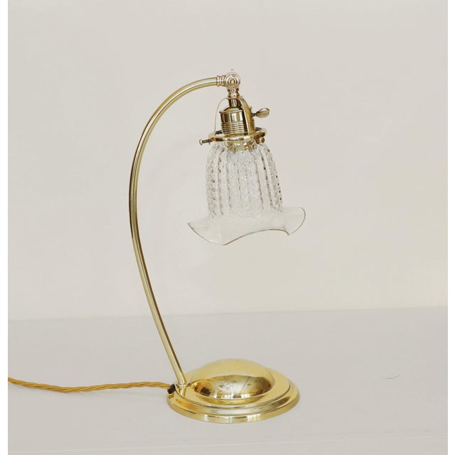 Art Deco floor lamp Brass table lamp, circa 1920. Heavy, round base, curved arm. Clear glass shade, adjustable and...